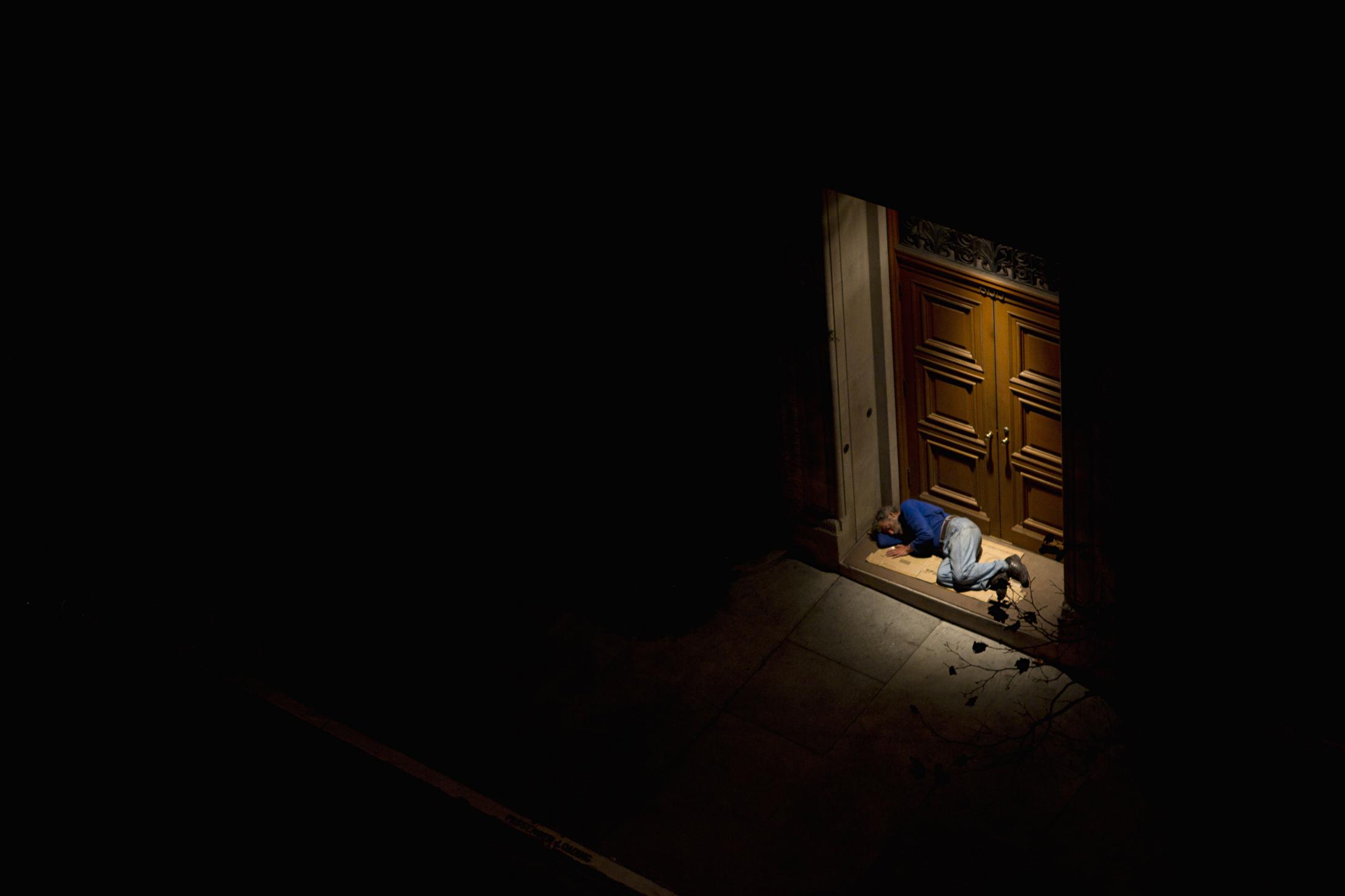SINGLES -  A homeless man sleeps in front of a door on Thursday,...