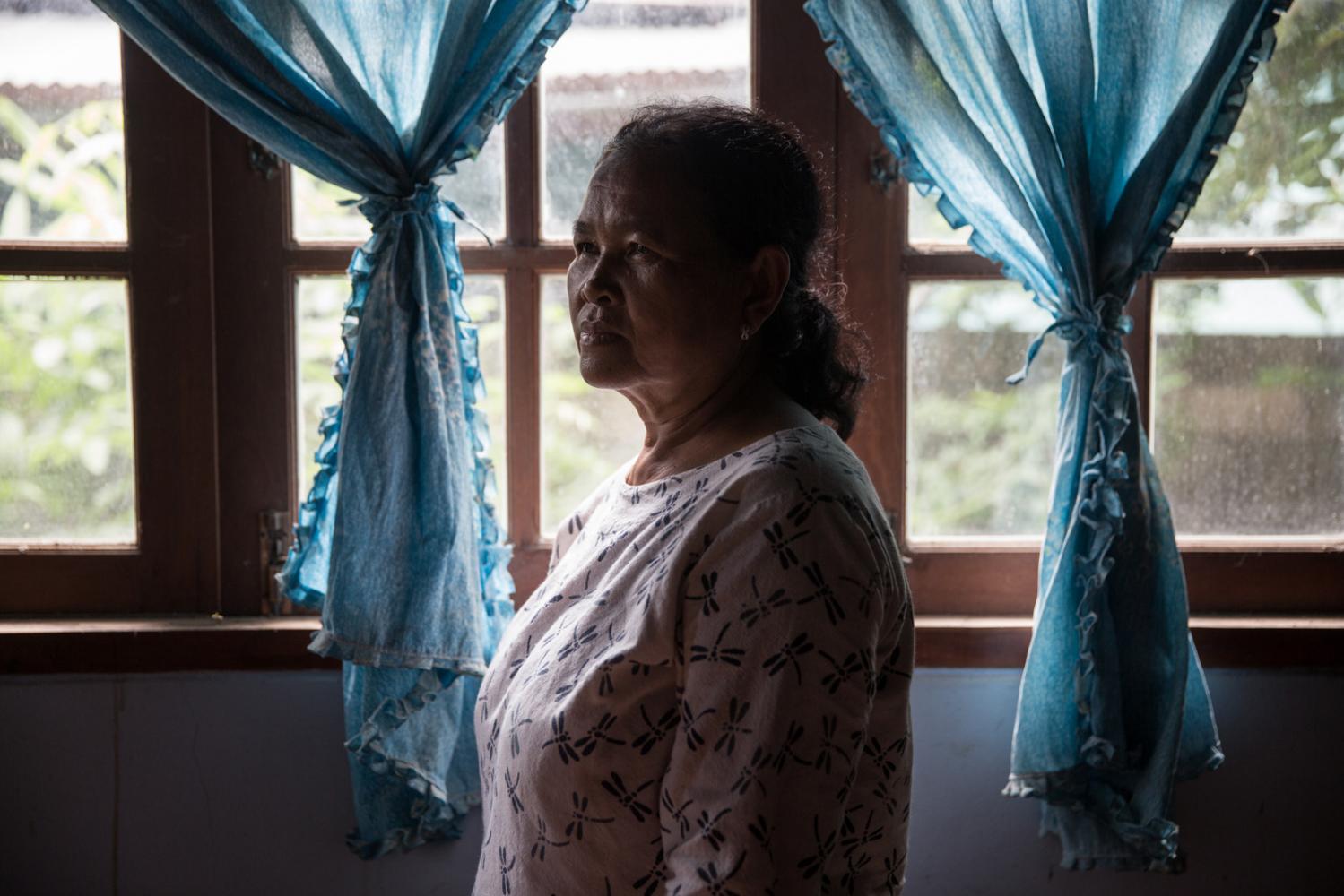 Lamduan Wongkhamchan, a core member of the community group, stands inside her house in Chok Chai...