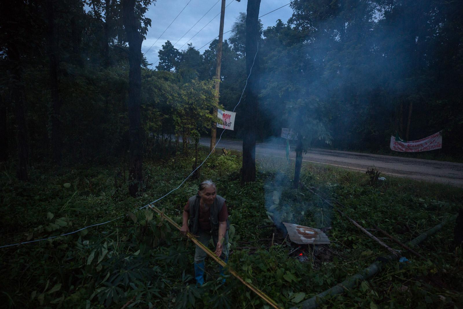 ONE LAST STAND - A villager makes a fire to keep mosquitos away at the...