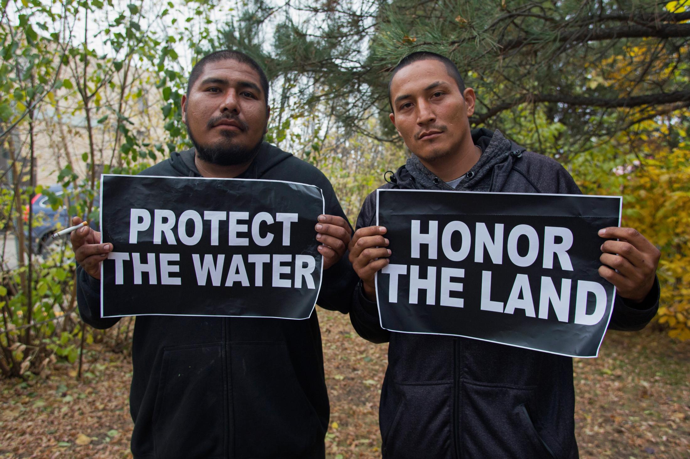Decolonizing Water - Emerson Bobtail Bear, left, and David Red Bear Jr. hold...