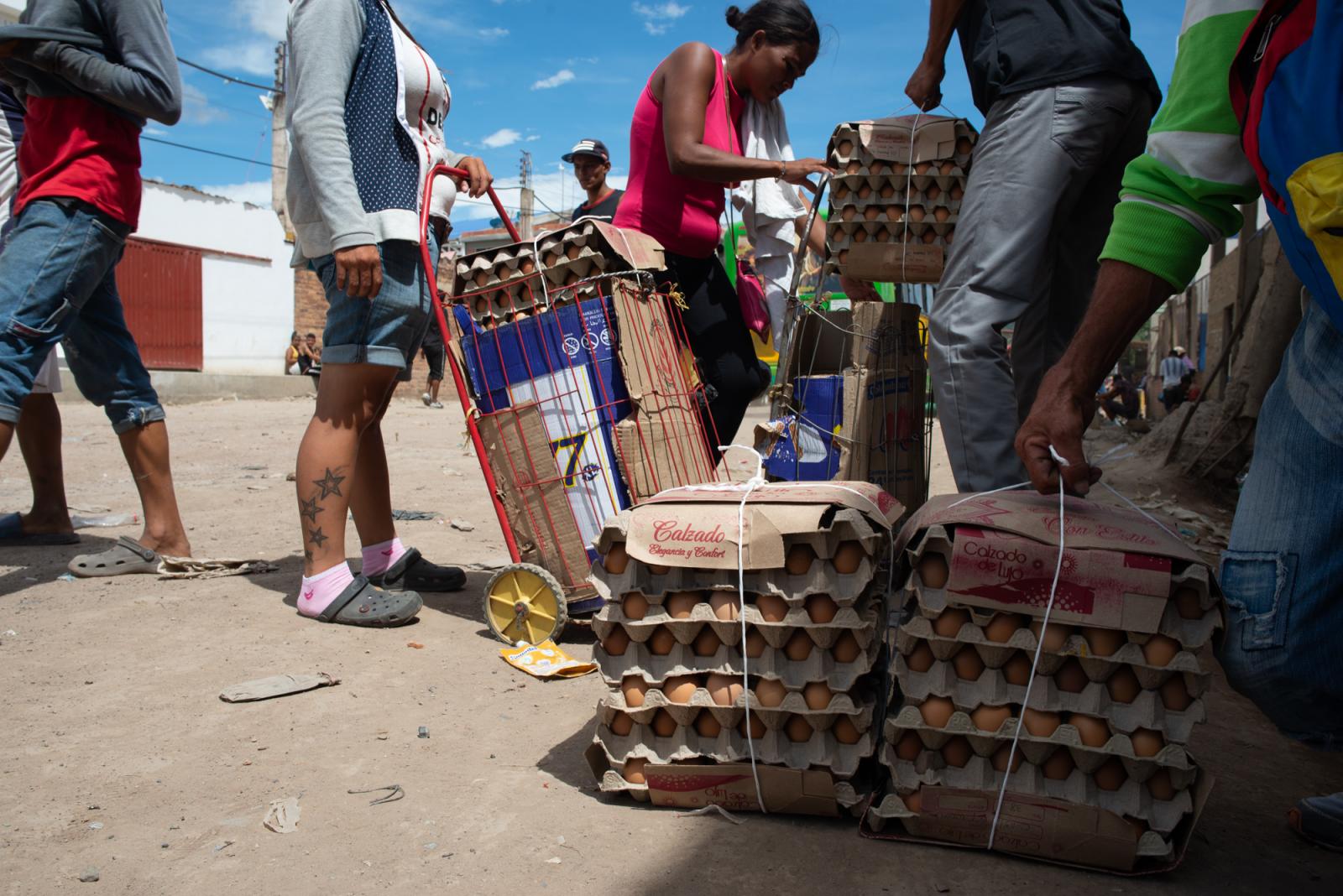 Zully and Nelly are charging their carts with eggs and other goods to carry over to Venezuela....
