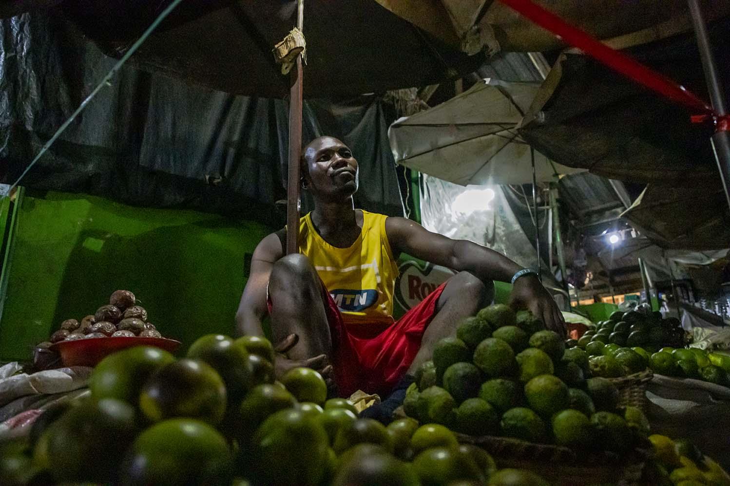 Basalirwa Godfrey, a Nakawa Market vendor, has a bicycle but could not ride it to his home and back everyday because he lives too far. His first night sleeping in market seemed safe, so he decided to join his colleague sleeping over. Godfrey rode home every weekend to check on his family.