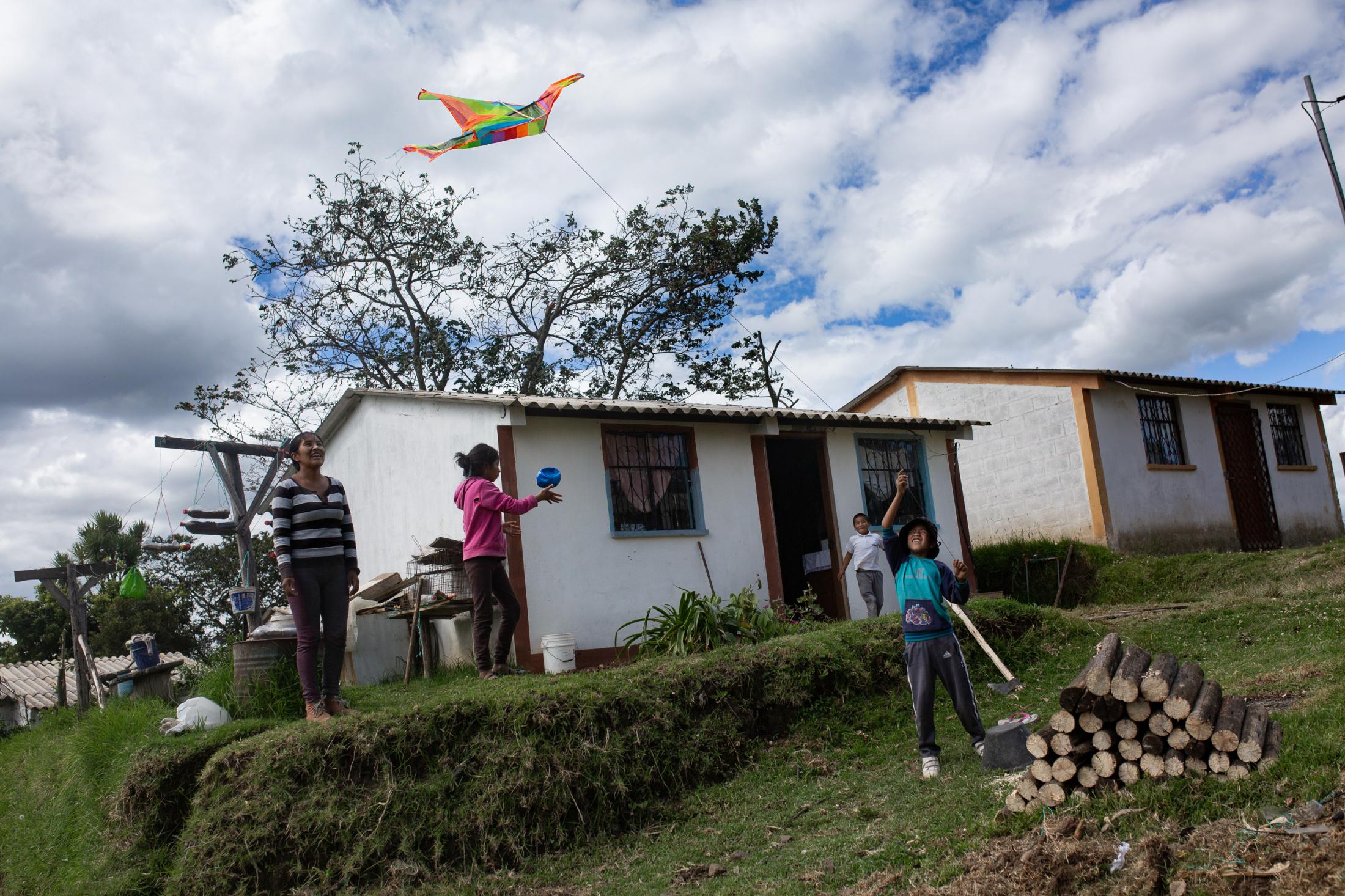 Sandra Guallichico (32) along with her children Celina (12), C&eacute;sar (8) and Francisco (11) spend part of their day outside the house, playing, taking care of their plants. When the weather permits, they like to go out and fly kites. May 26th, 2020. Cotogchoa-Ecuador. Andr&eacute;s Y&eacute;pez. Everyday life in rural areas has been affected differently than in urban areas. Their confinement is not limited to being inside the house. The countryside is part of their home.