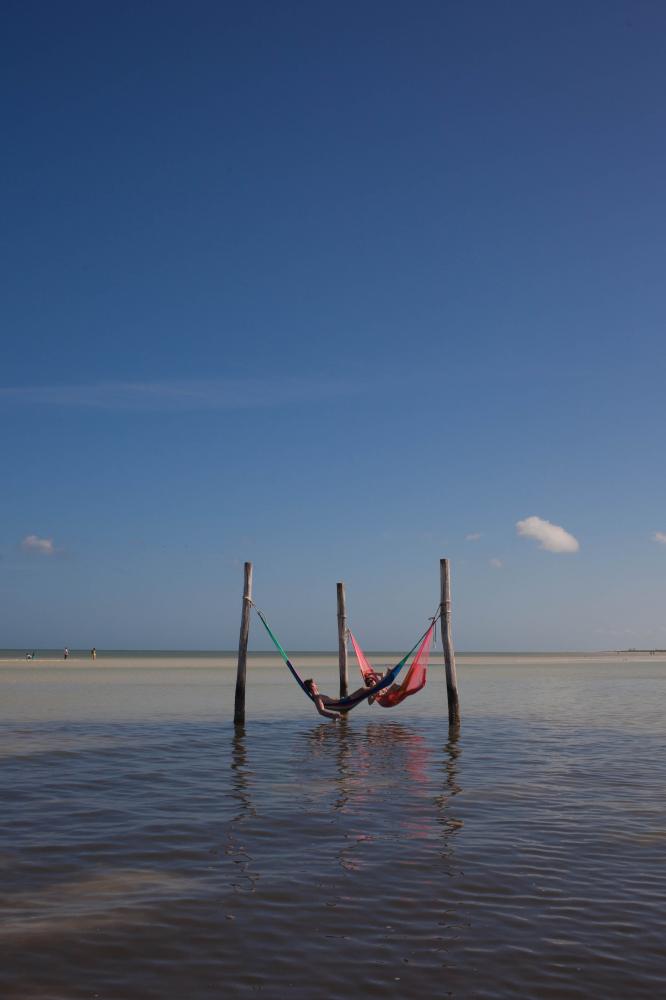Image from Food & Travel - Tourists relax on a hammock in the ocean in Isla Holbox,...