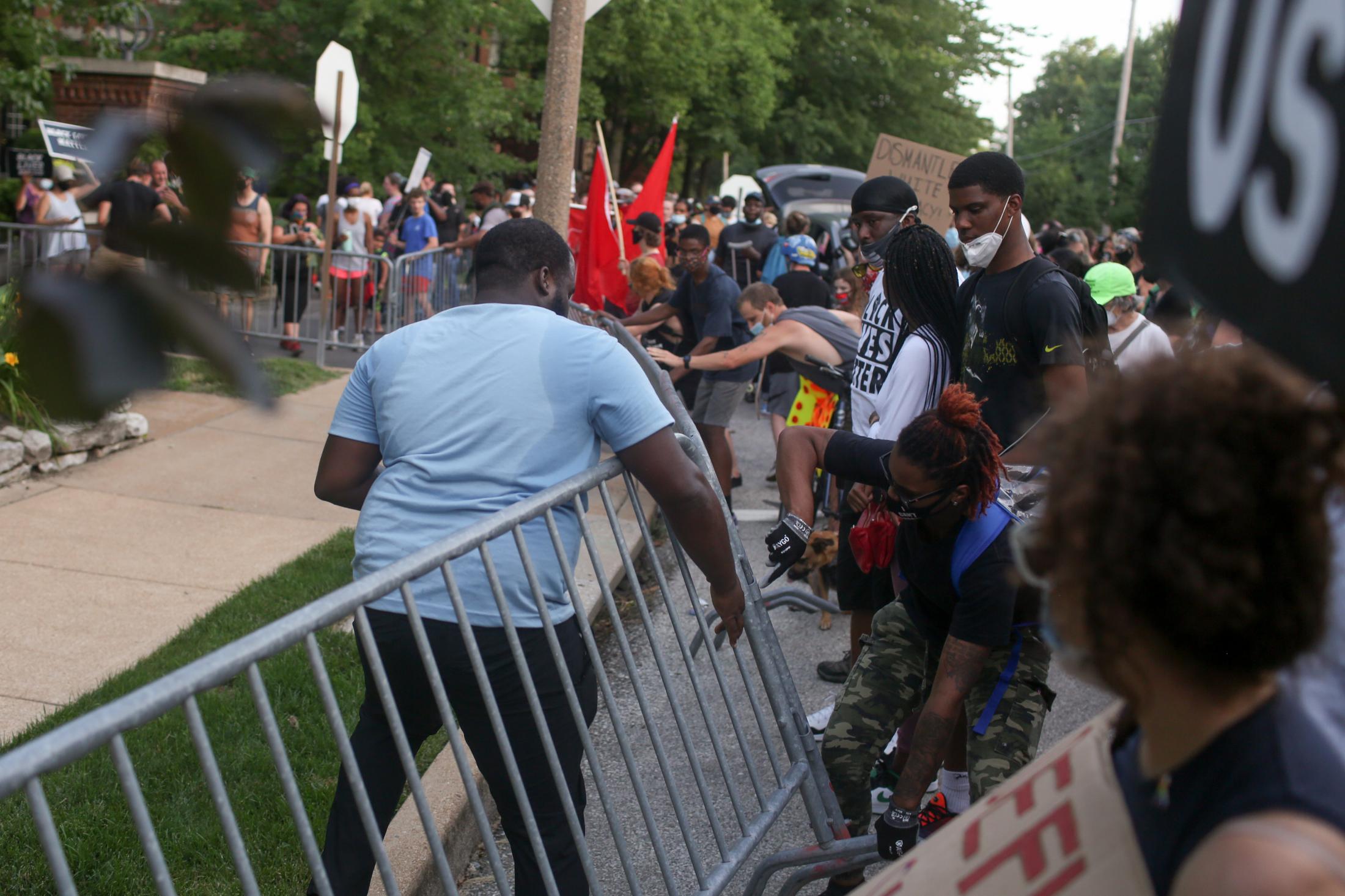 Portland Place - Protesters topple a fence near St. Louis Mayor Lyda...