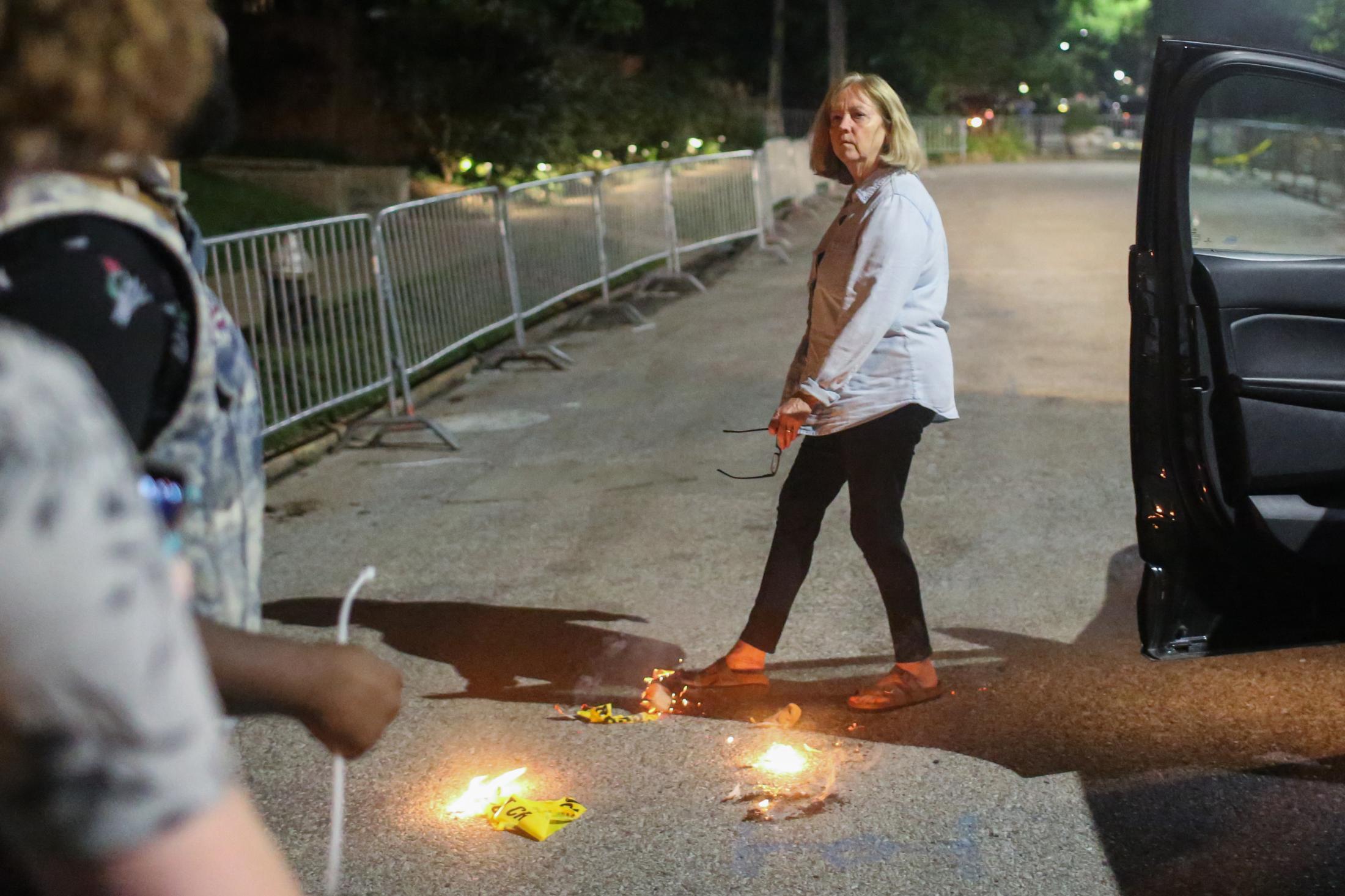 Portland Place - St. Louis Mayor Lyda Krewson stomps out a small fire that...