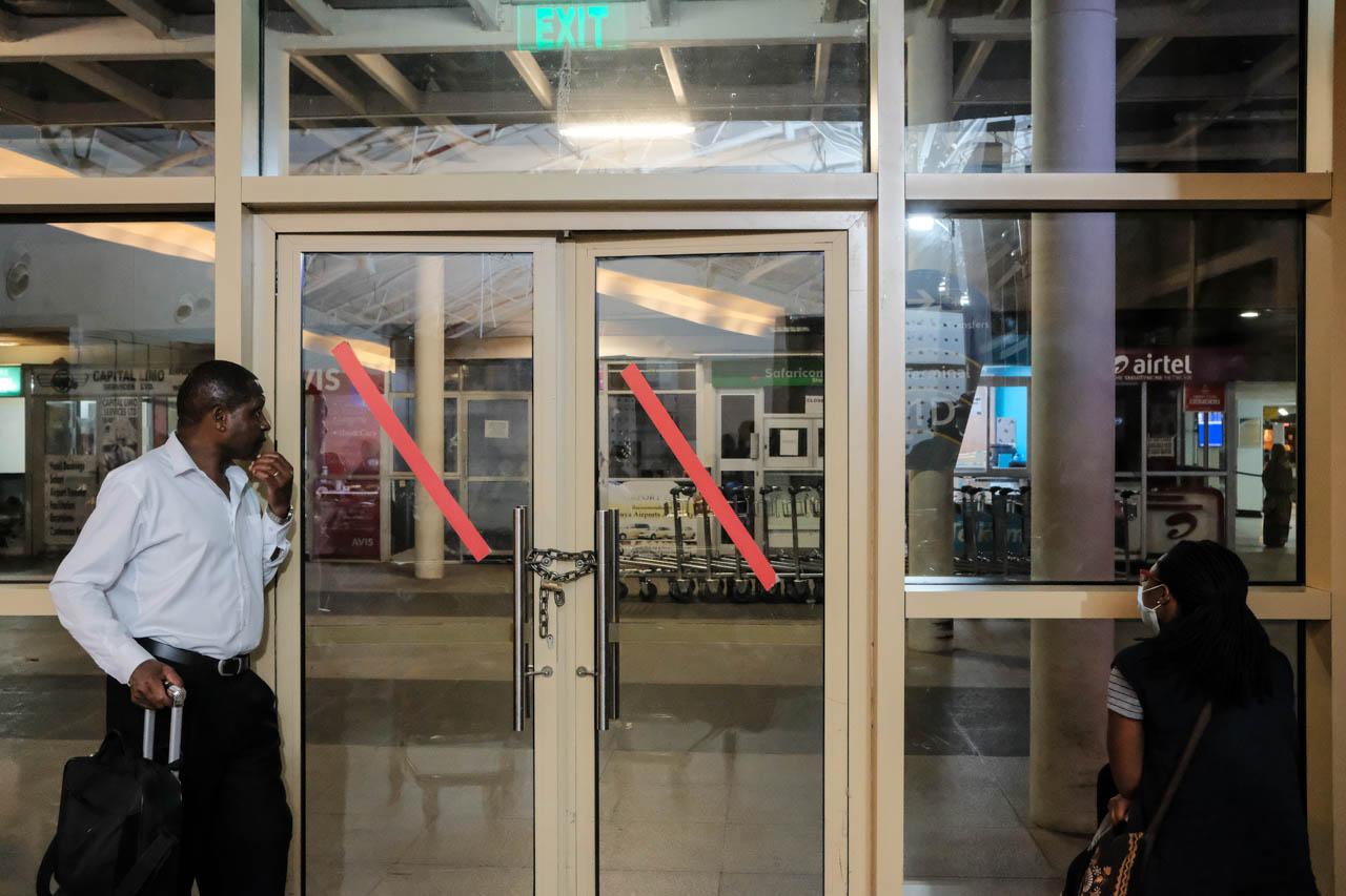 Kabir Dhanji | COVID-19 Quarantine Nairobi - Passengers wait by doors locked and chained at the exit...