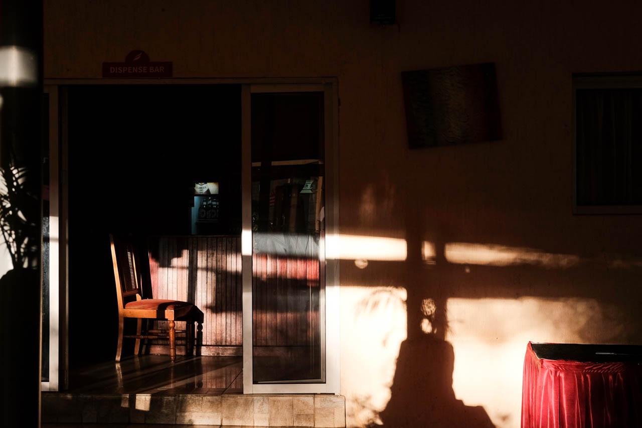 Kabir Dhanji | COVID-19 Quarantine Nairobi - The afternoon sun sits alone across an empty bar at a...