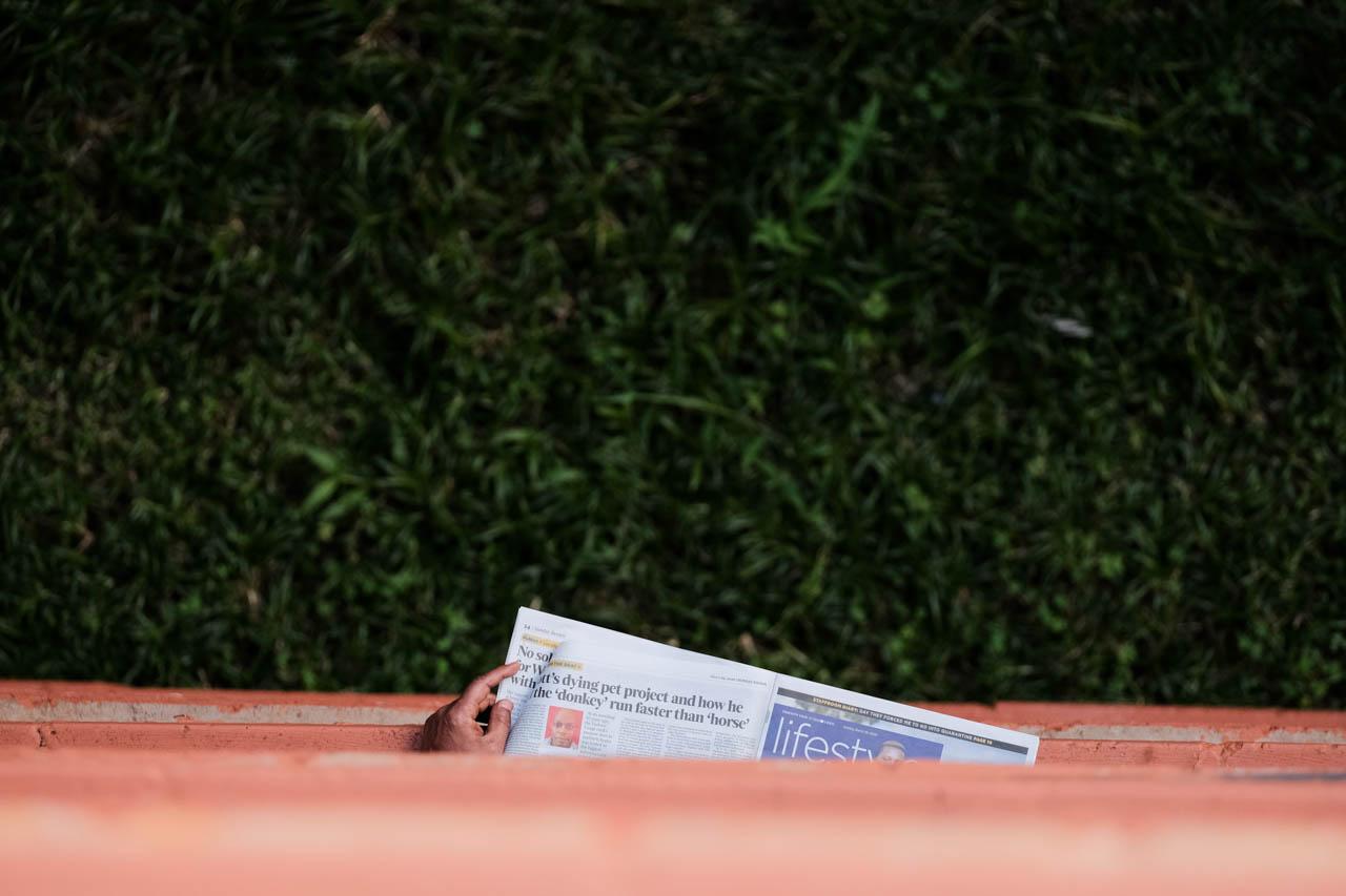 Kabir Dhanji | COVID-19 Quarantine Nairobi - A man reads the newspaper at a Government designated...