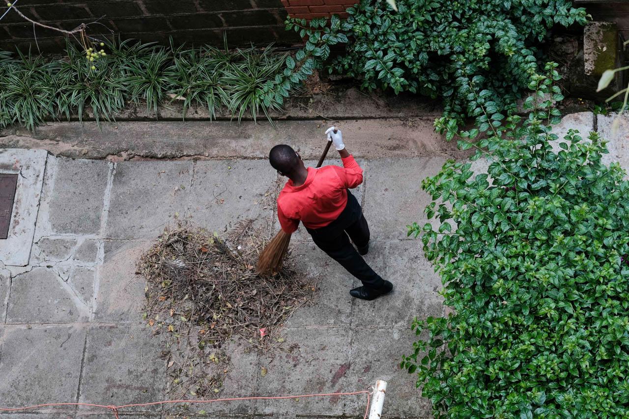 Kabir Dhanji | COVID-19 Quarantine Nairobi - A hotel employee sweeps an unused patio at a Government...