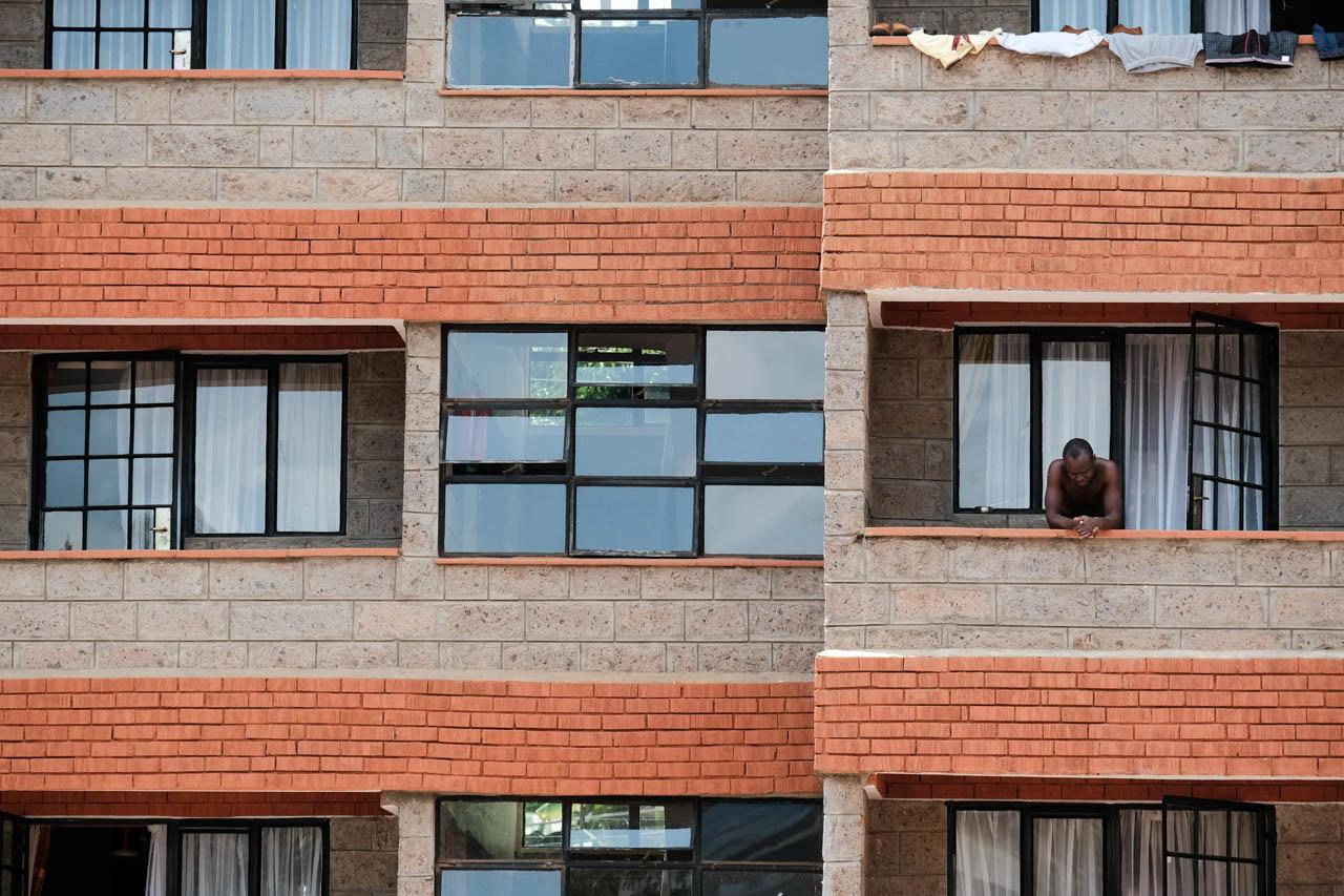 Kabir Dhanji | COVID-19 Quarantine Nairobi - A man contemplates the empty balconies in isolation at a...
