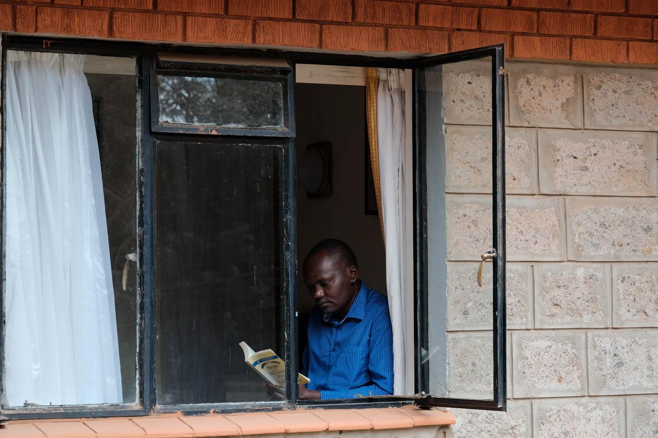 Kabir Dhanji | COVID-19 Quarantine Nairobi - A man reads a book to pass the time at a Government...