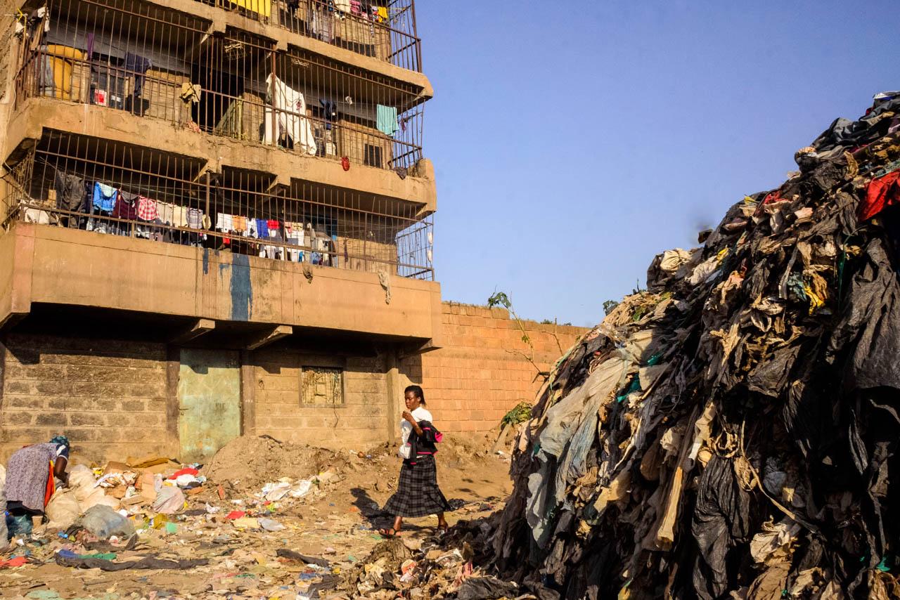 A woman walks through a heap of trash in Dandora Landfill.