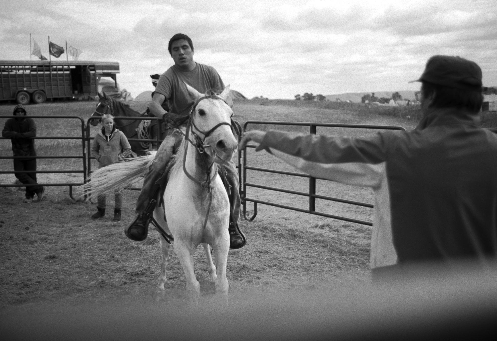 Standing Rock - Phillip Bird Horse (right), a horsemanship associate at...