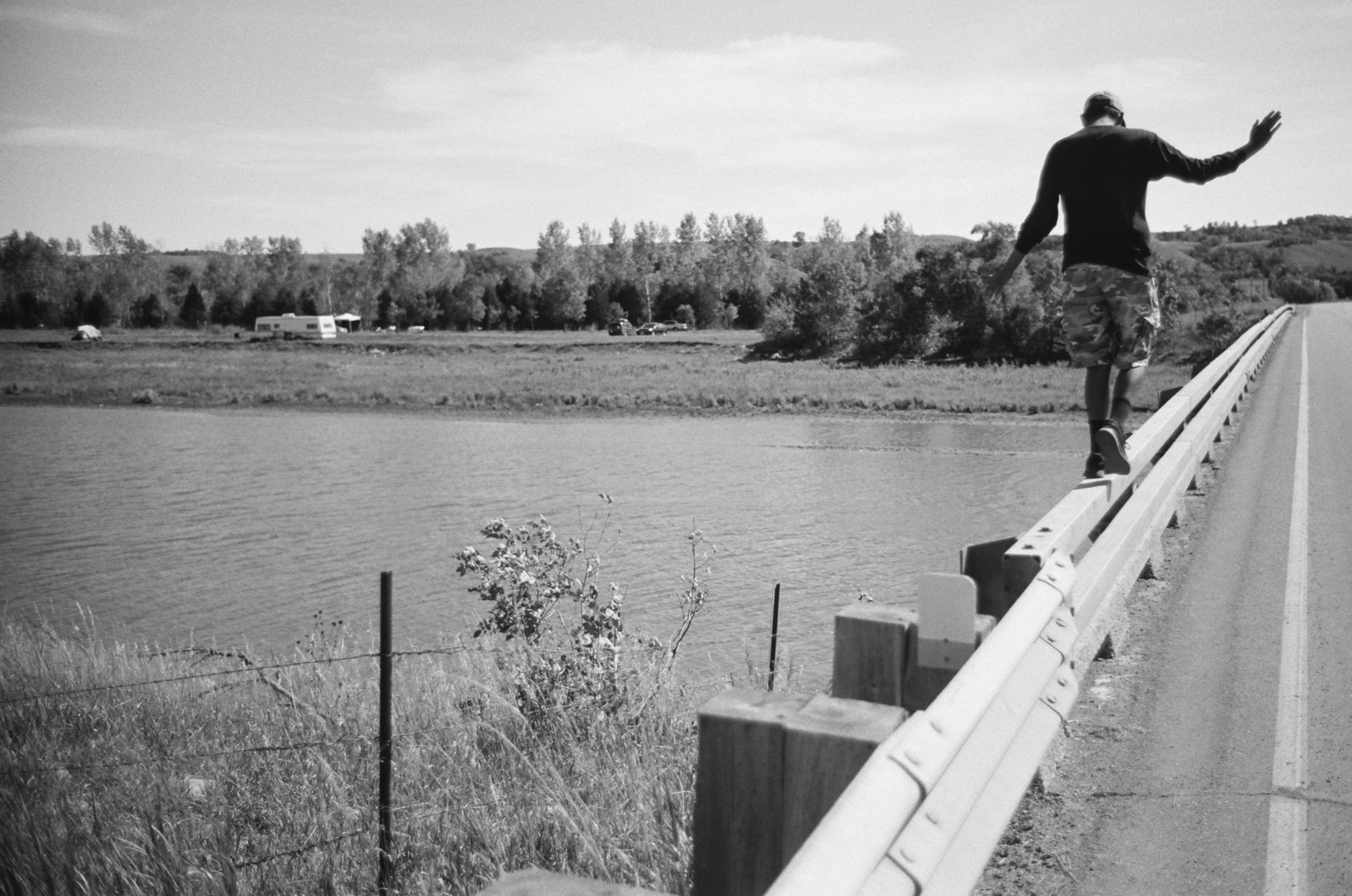 Standing Rock - A man walks on the bridge over the Cannonball River...