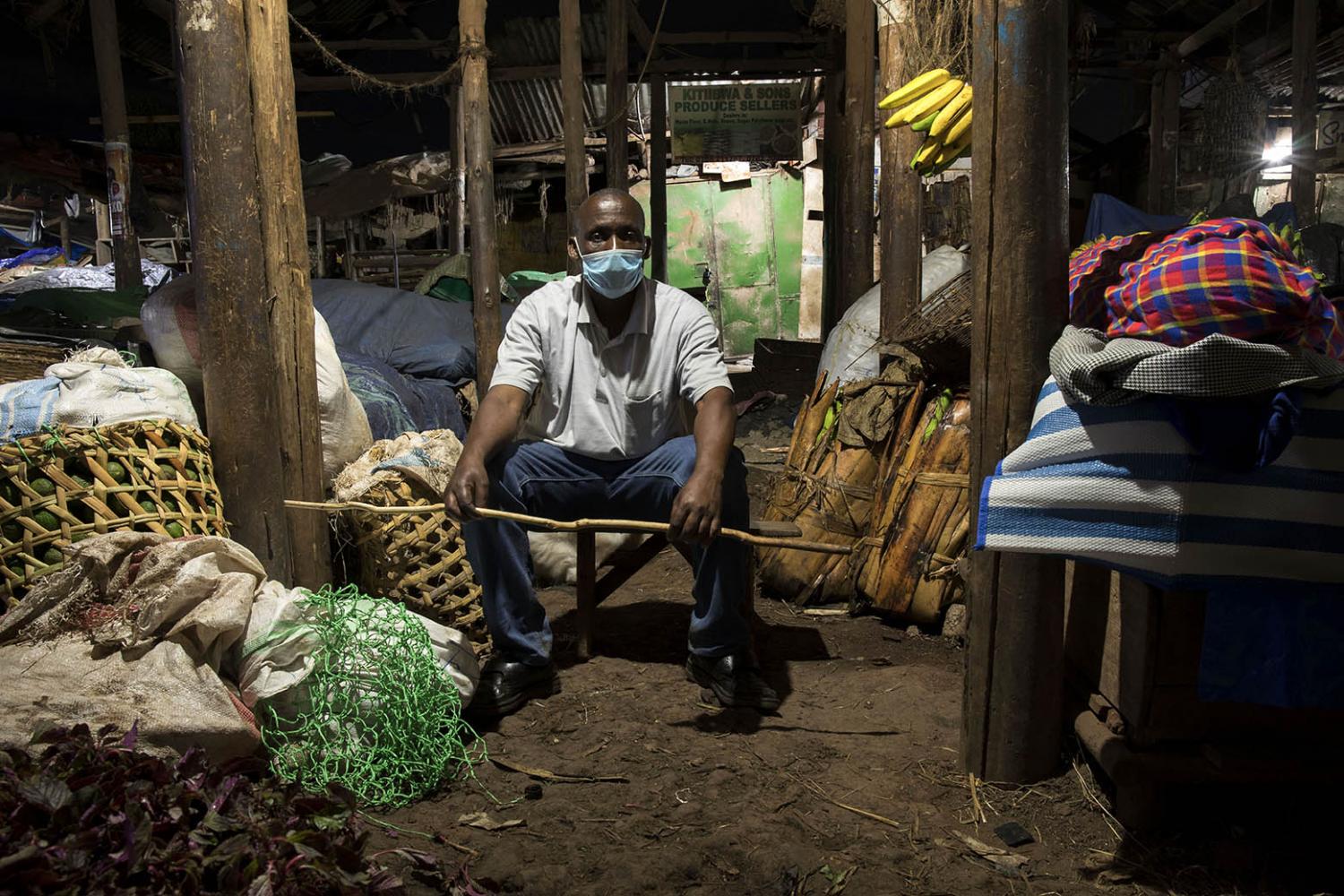 Charles Bugembe, the chairperson of a Busega market in Kampala, poses with a cane to enforce a...