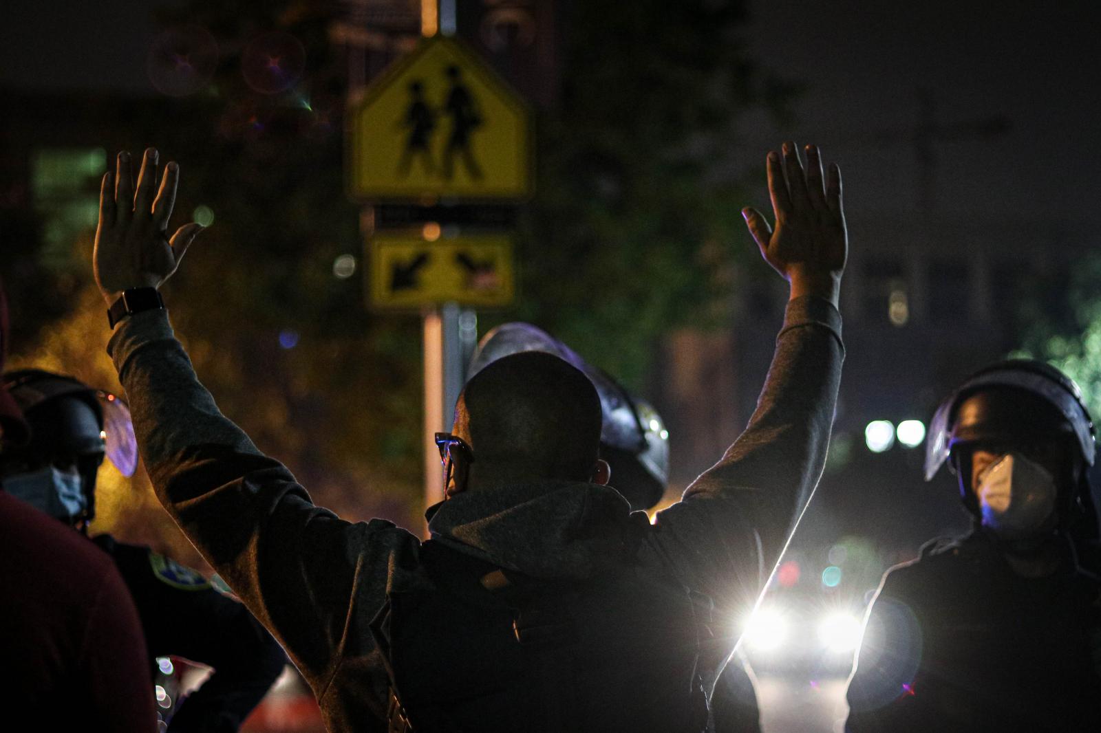 A protester raises his hands up...Oakland, Calif., Aug. 28, 2020)