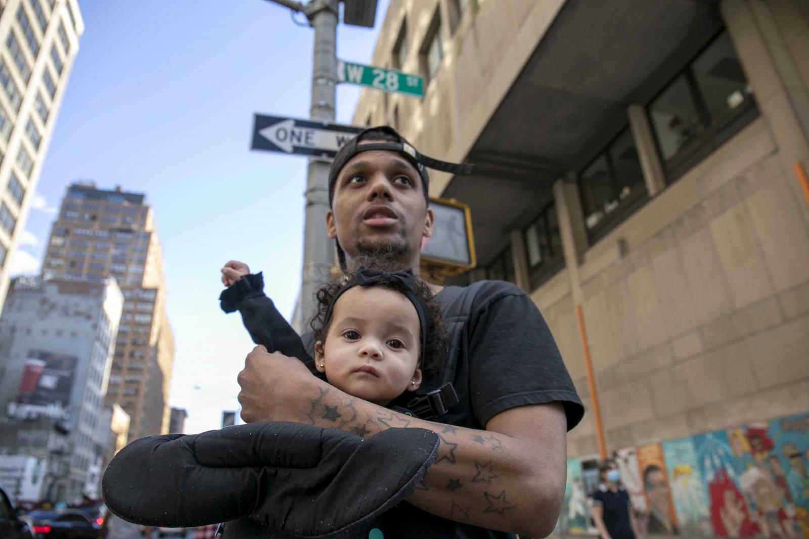 Joshua holds his 8-month-old da...communities of color. &not;