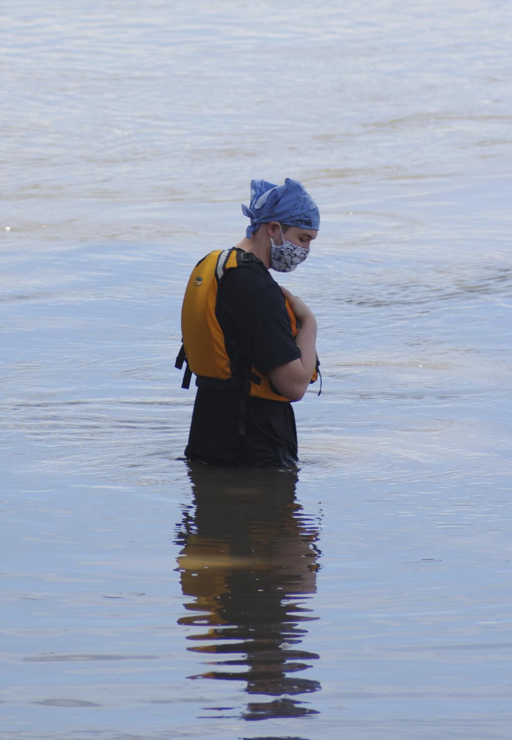 Volunteer Matthew Hall watches the ripples in the Missouri River as he waits for the boat racers to arrive on August 5, 2020, at Cooper&rsquo;s Landing. Hall started volunteering for the Missouri River 340 race around five years ago. Hall&rsquo;s grandfather used to compete in the race and Hall was planning on competing as well with a family friend. After the friend couldn&rsquo;t compete tandem with him, Hall started to volunteer.