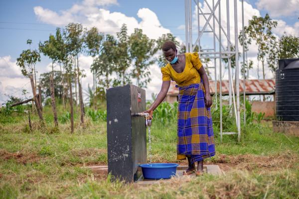 Photography - A woman collecting clean water at the motorised water...