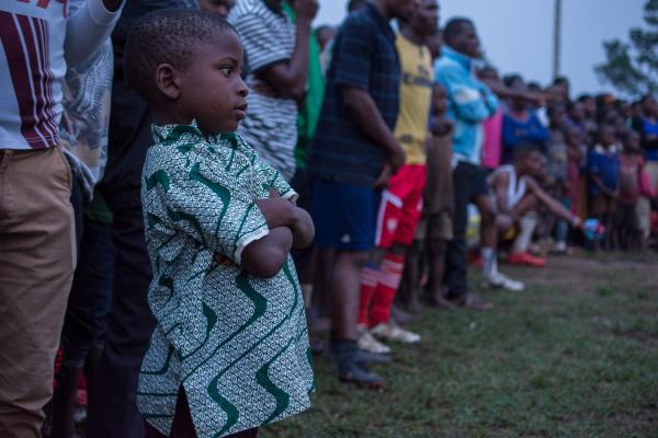 Image from ROAD TO UGANDA DECIDES - A young soccer fan looks on during the soccer match.