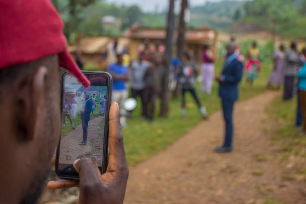 ROAD TO UGANDA DECIDES - A young man takes a picture of Arans Mark Tabaruka, a...