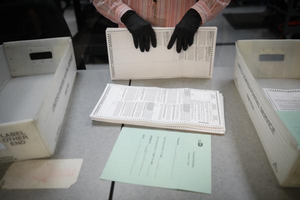 Image from 2020 - Presidential Elections @ Miami, FL - An electoral worker organizes vote-by-mail ballots at...