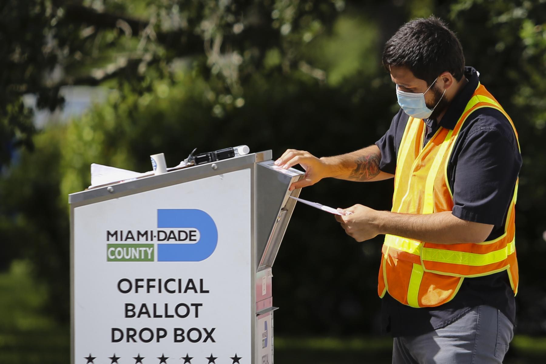 Election 2020 @ Miami, FL - A poll worker drops off a vote-by-mail ballot at a Ballot...
