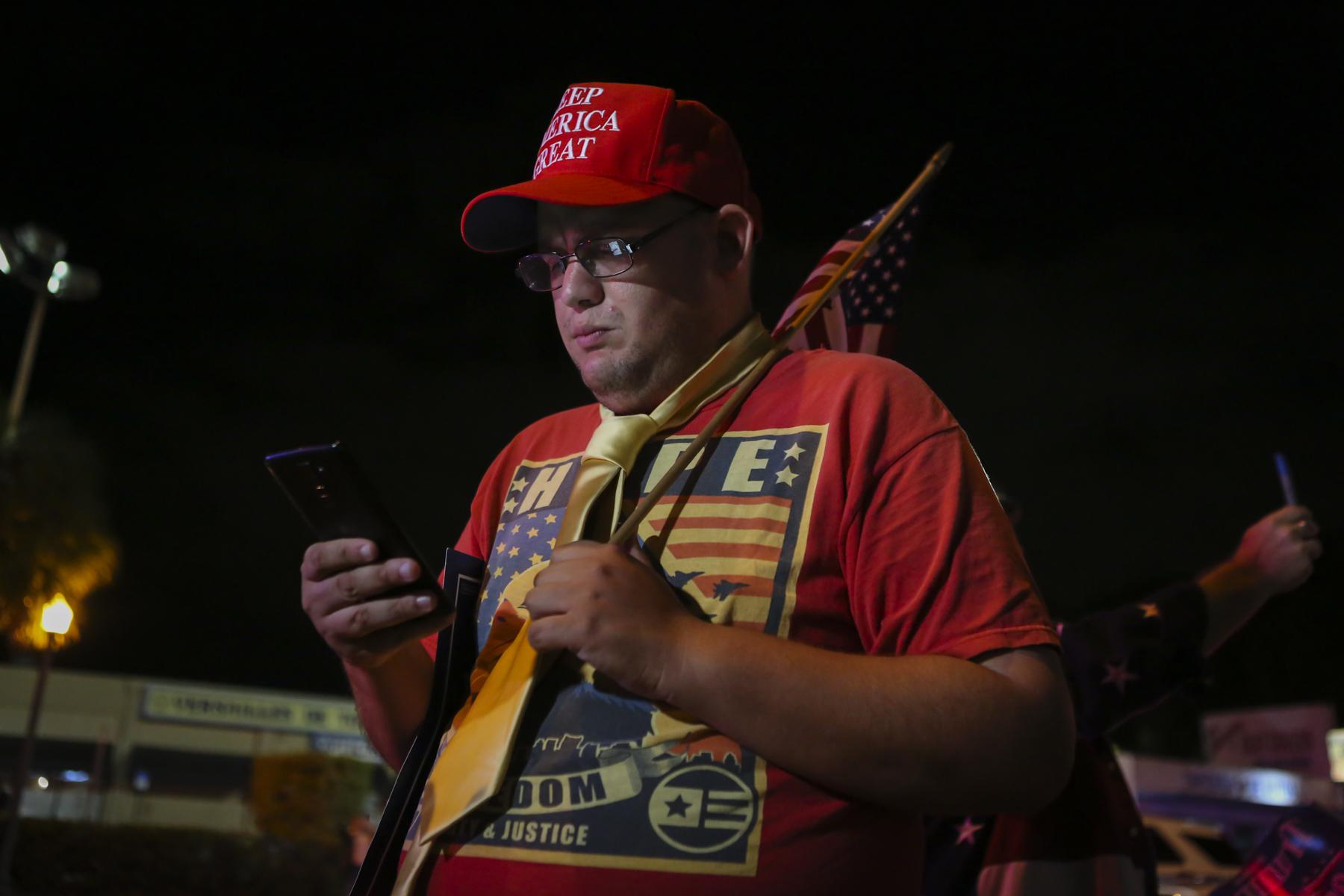 Election 2020 @ Miami, FL - A supporters of President Donald Trump uses his phone...