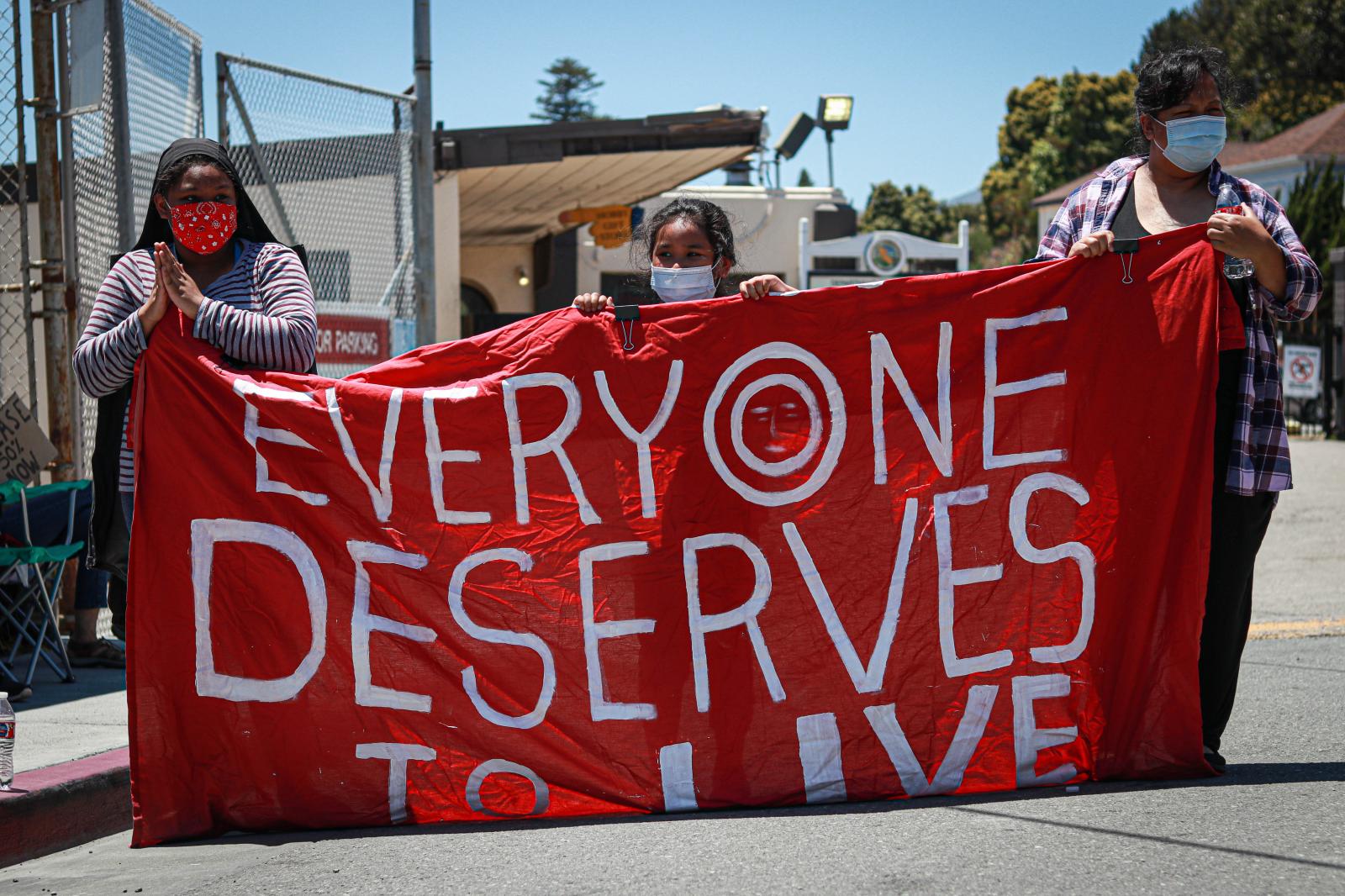 Protesters hold a banner with t...ka Maddala/ Golden Gate Xpress)