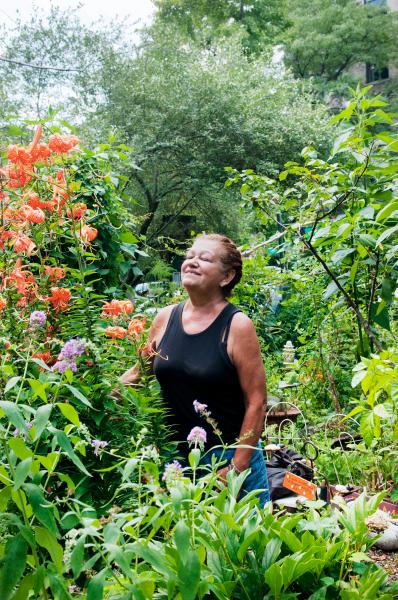 Image from Green Oases in the City - Marta Montanez stands in the garden that she takes care...