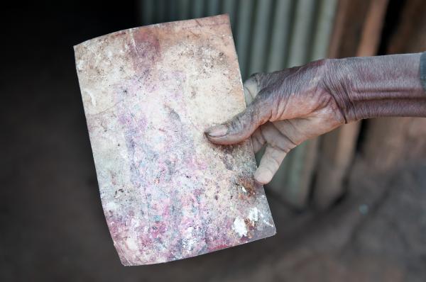 Image from Parenting the Missing - Odora Nakumiya holds the picture of his deceased wife...