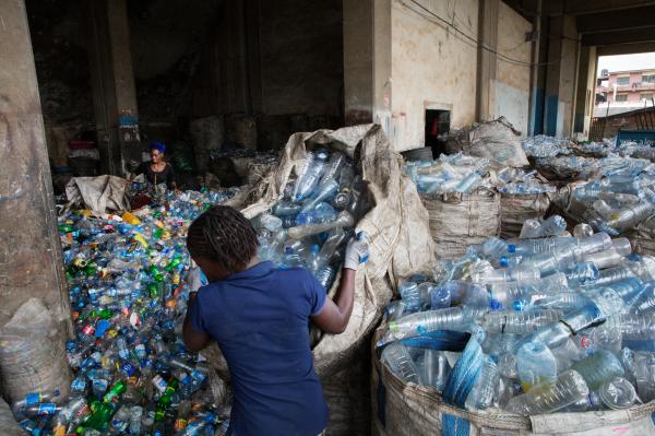 Recycling Lagos  - Sorter Damilola Adetayo moves a bag full of plastic...