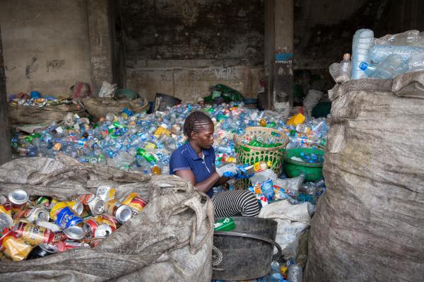 Image from Recycling Lagos  - Sorter Damilola Adetayo uses a knife to remove labels...