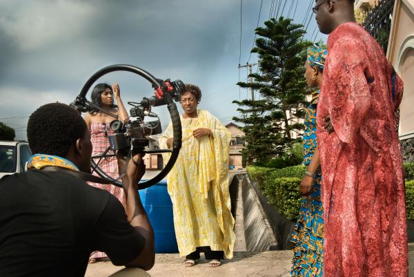 Image from Nollywood: Cinema of Nigeria -  Director Ola Orlando Shoyinka (far left) uses a digital...