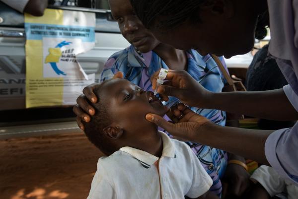 NGO Work - Boy receives a drop of oral polio vaccine during...