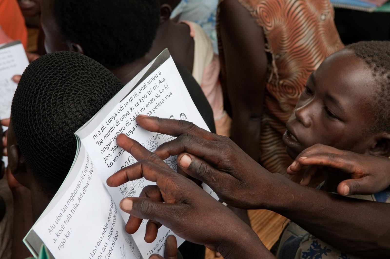 Children and adults read during...Adjumani, Uganda. (LABE Uganda)