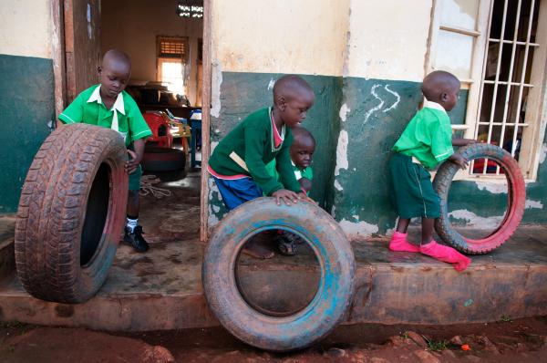 Image from NGO Work - During recess, children bring tires from the Nursery...