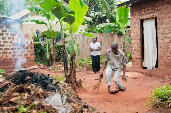 NGO Work - Jamada Maviiri sweeps his compound in Katale Village,...