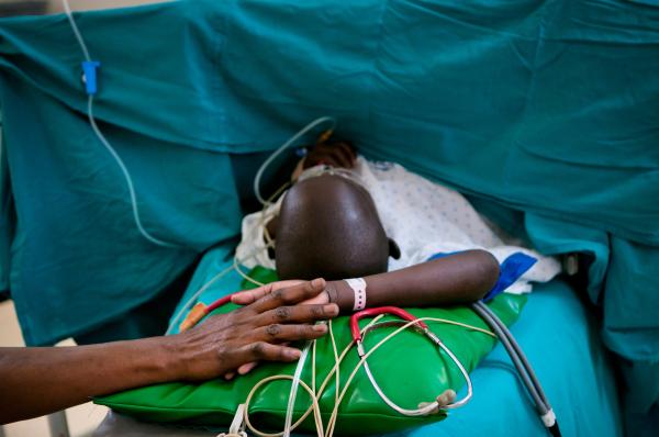 NGO Work - Nurse holds Sharon Amukye's hand while she’s...