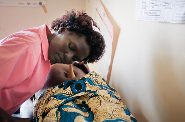 NGO Work - Nurse Auma Cecilia listens to a baby's heartbeat...