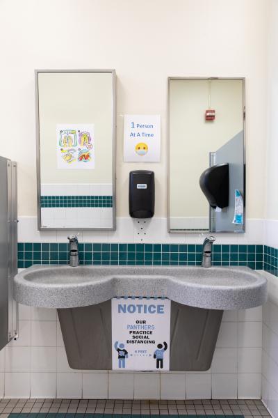 Image from Spaces and Signs (COVID-19) - In the bathrooms, posters remind students to observe...