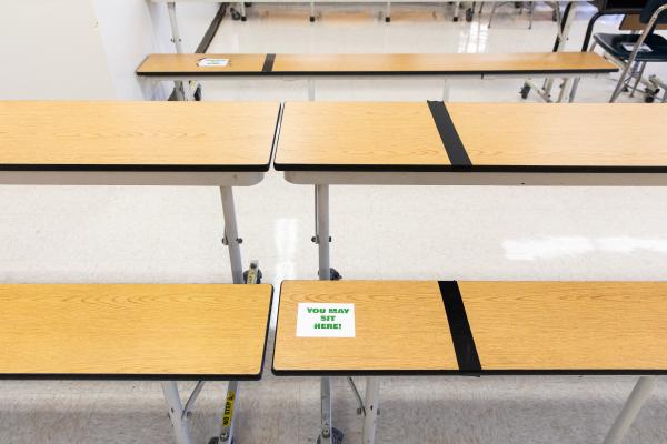 Spaces and Signs (COVID-19) - Signs on benches in the auditorium tell students where to...