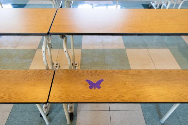 Image from Spaces and Signs (COVID-19) - Signs on benches in the auditorium tell students where to...
