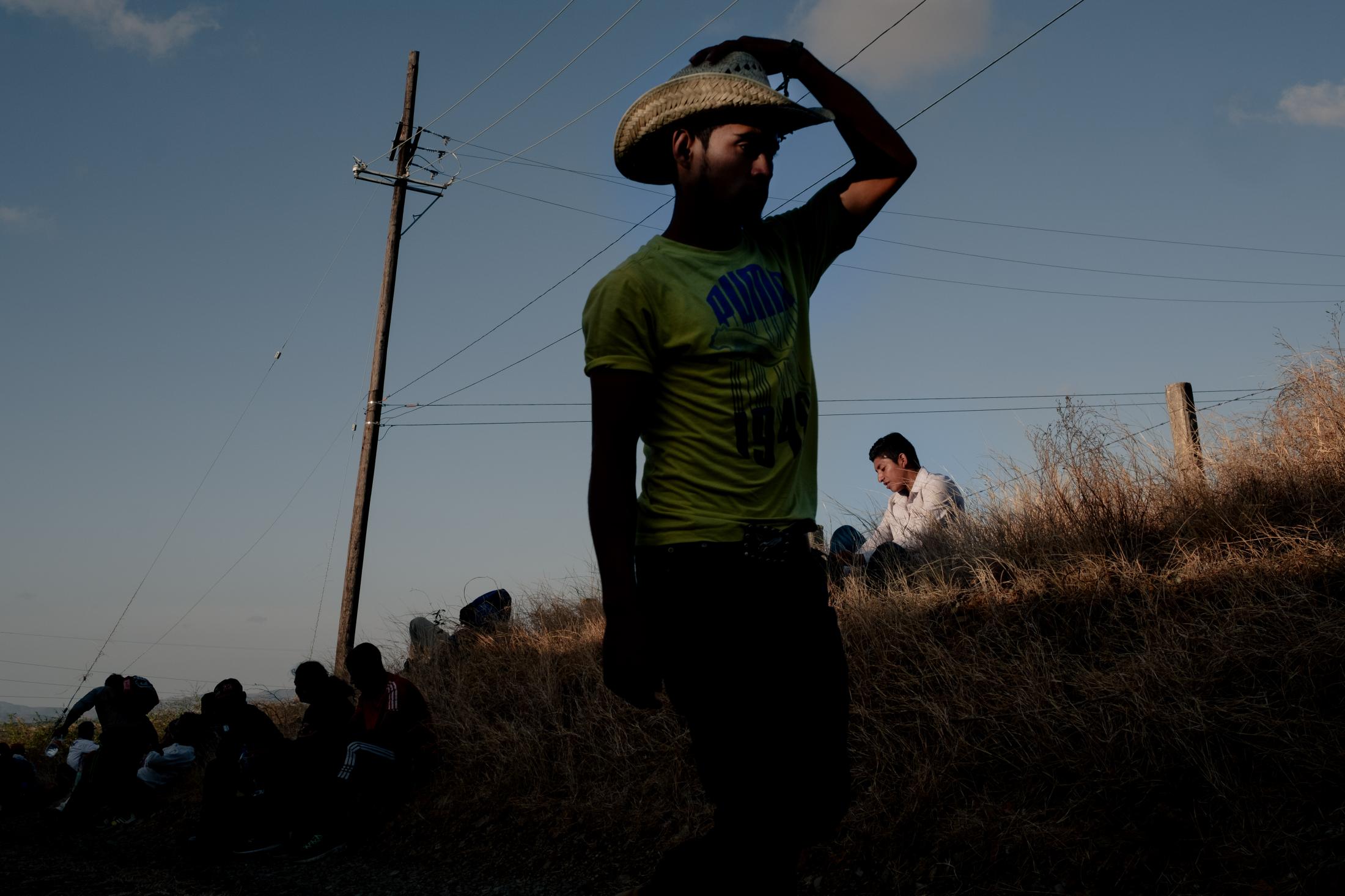 Southern Border - Migrants from the caravan rest in a field near the road...