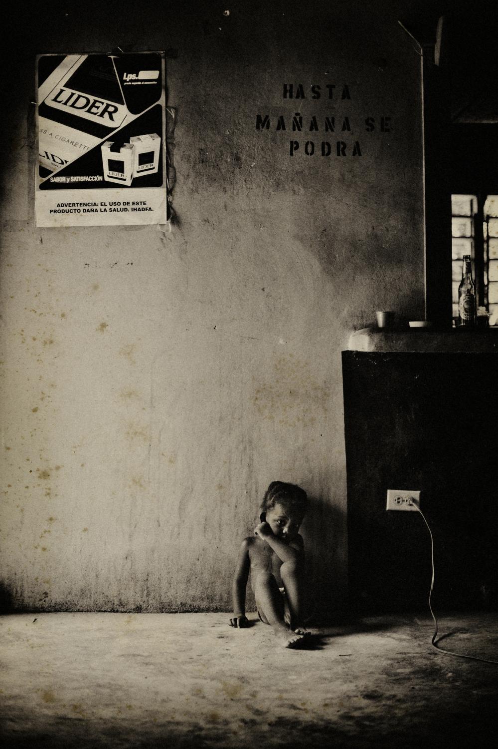 Orphans of the storm - Honduras.
February 2008.
A young girl sitting inside a...