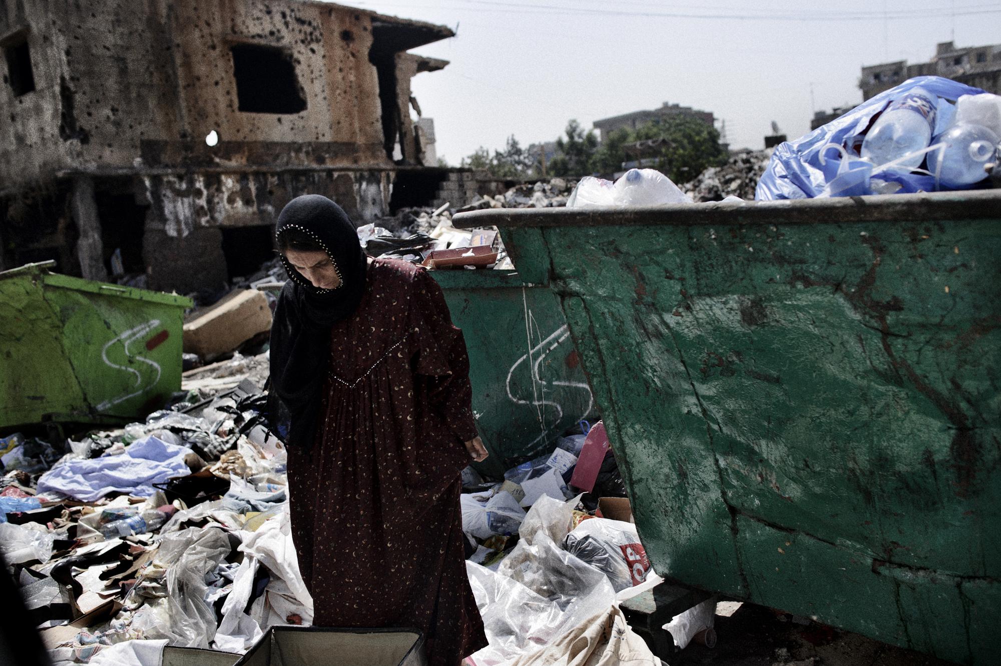 A women trying to find something valuable at the garbage dump of the overcrowded Beirut outskirts Sabra and Shatila in Lebanon, home to refugees from the occupied Palestinian territories, Syria, Armenia, and foreign domestic workers from the Philippiâ€‹nes, Sudan and Sri Lanka.