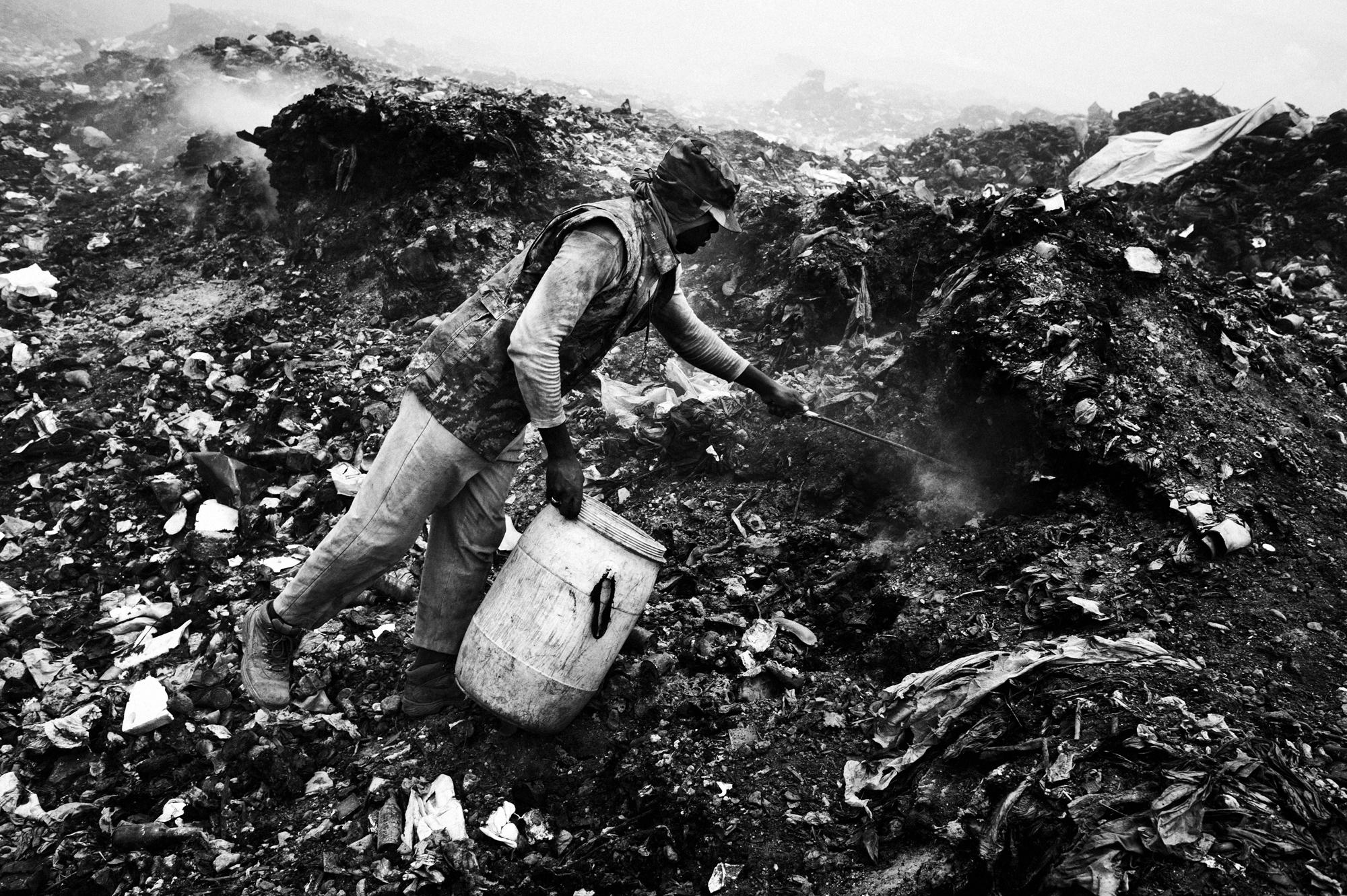 Private hell - Port au Prince.June 2010.A man walks through a garbage...