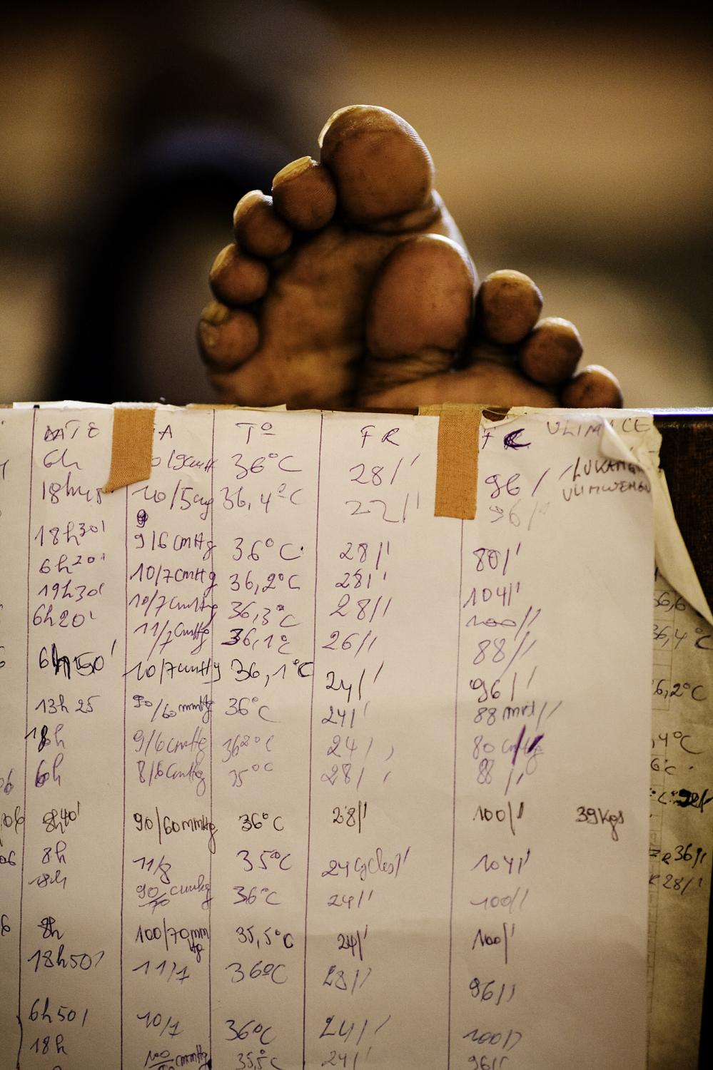 DEMOCRATIC REPUBLIC OF CONGO Bukavu, South Kivu Province A hospital chart is taped to the end of a bed near the feet of a resting AIDS patient at...