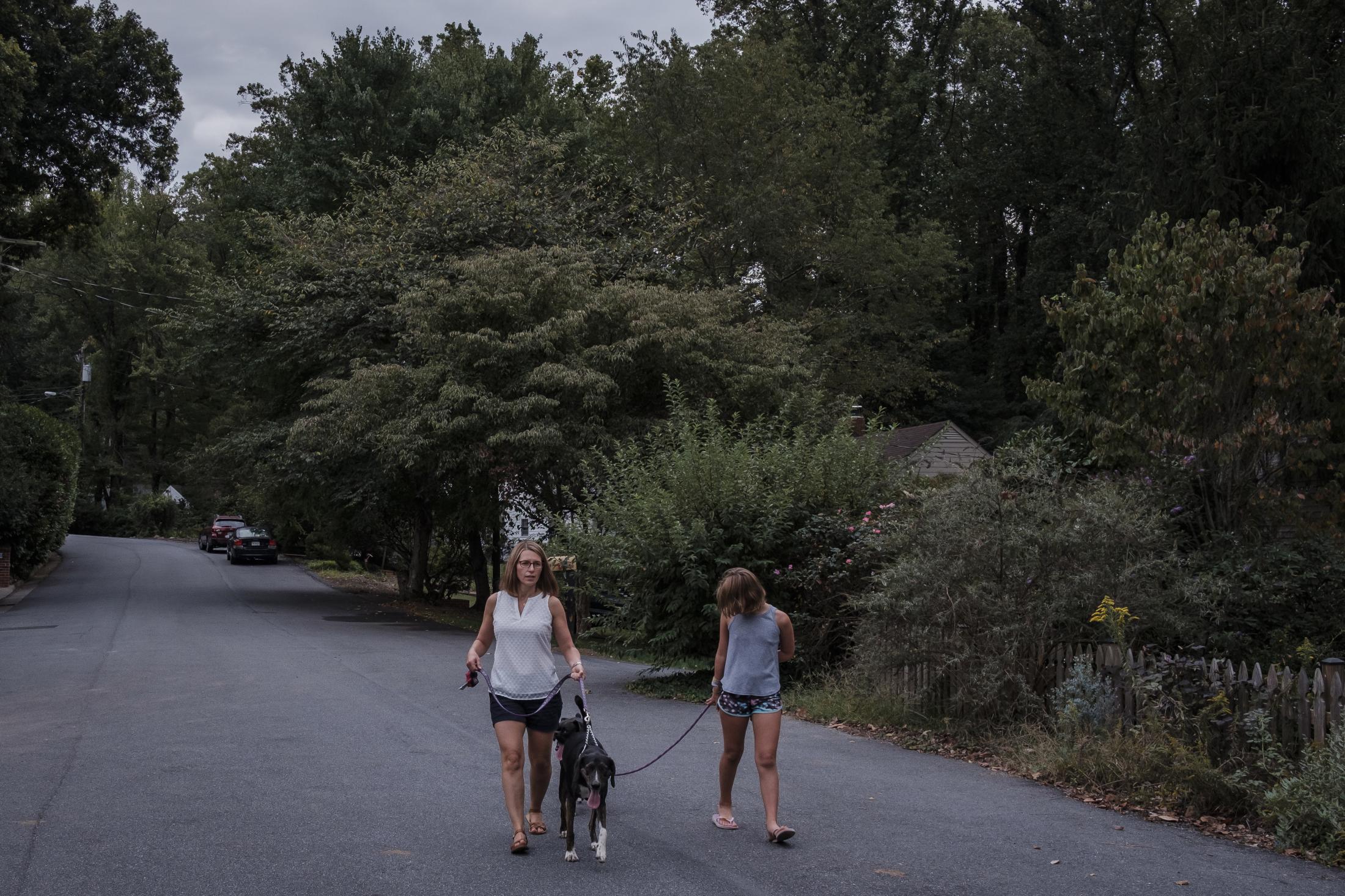 Jeri Seidman and her daughter Hannah taking their dogs Perri (Boxer) and Quin (Hound) for a walk in Charlottesville, Virginia, U.S., on Monday Sept. 23, 2019. Hannah is a patient in a genetic risk study about type 1 diabetes at University of Virginia. Photographer: Carlos Bernate/ NPR